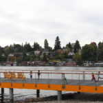 Children running on dock with yellow Maglin 720 chairs overlooking water and houses
