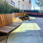 Curved Ogden cantilever benches surrounded by gardens and greenery at Grandscape