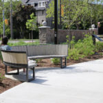 Student sitting on curved bench enjoying the outdoors on a sunny day at University of Guelph Lang Plaza