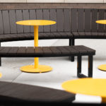 Yellow powdercoated Ogden cafe tables shown with Ogden Backed and Backless Benches