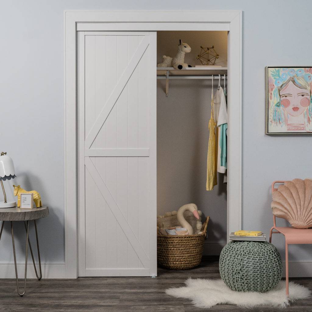 White K Design Bypass Closet Door in a childrens room with pastel toys in closet.