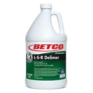 A gallon container of BETCO SYMPLICITY L-S-R DELIMERPREMIUM Acid Base Lime Scale, a machine descaler and lime remover. White bottle with a green label and red Betco logo.