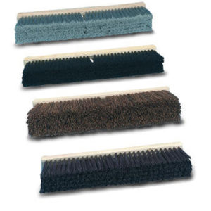 Four different colored broom heads are arranged in a vertical lineup. The colors are blue, black, brown, and gray. Each 36" PALMYRA PUSH BROOM W/ HARDWOOD BLOCK features dense bristles attached to a light-colored base.