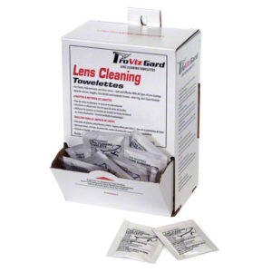 Box labeled "LENS CLEANING TOWELETTES10/100/BOX PER CASE" with individually wrapped packets shown inside the open box. Two towelette packets are displayed in front of the box.