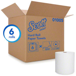 A cardboard box with "HARDWOUND ROLL TOWEL WHT 1PLY SCOTT 8" x 1000', 6/CASE" printed on it, containing 6 rolls of paper towels. One roll is shown outside the box.