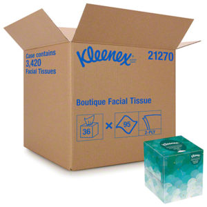 A large cardboard box labeled "FACIAL TISSUE BOUTIQUE WHT 2PLY KLEENEX" with "95/BOX, 36/CASE" and a partially open smaller teal tissue box with blue and white design.