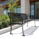 Metal bench with vertical slats outside 