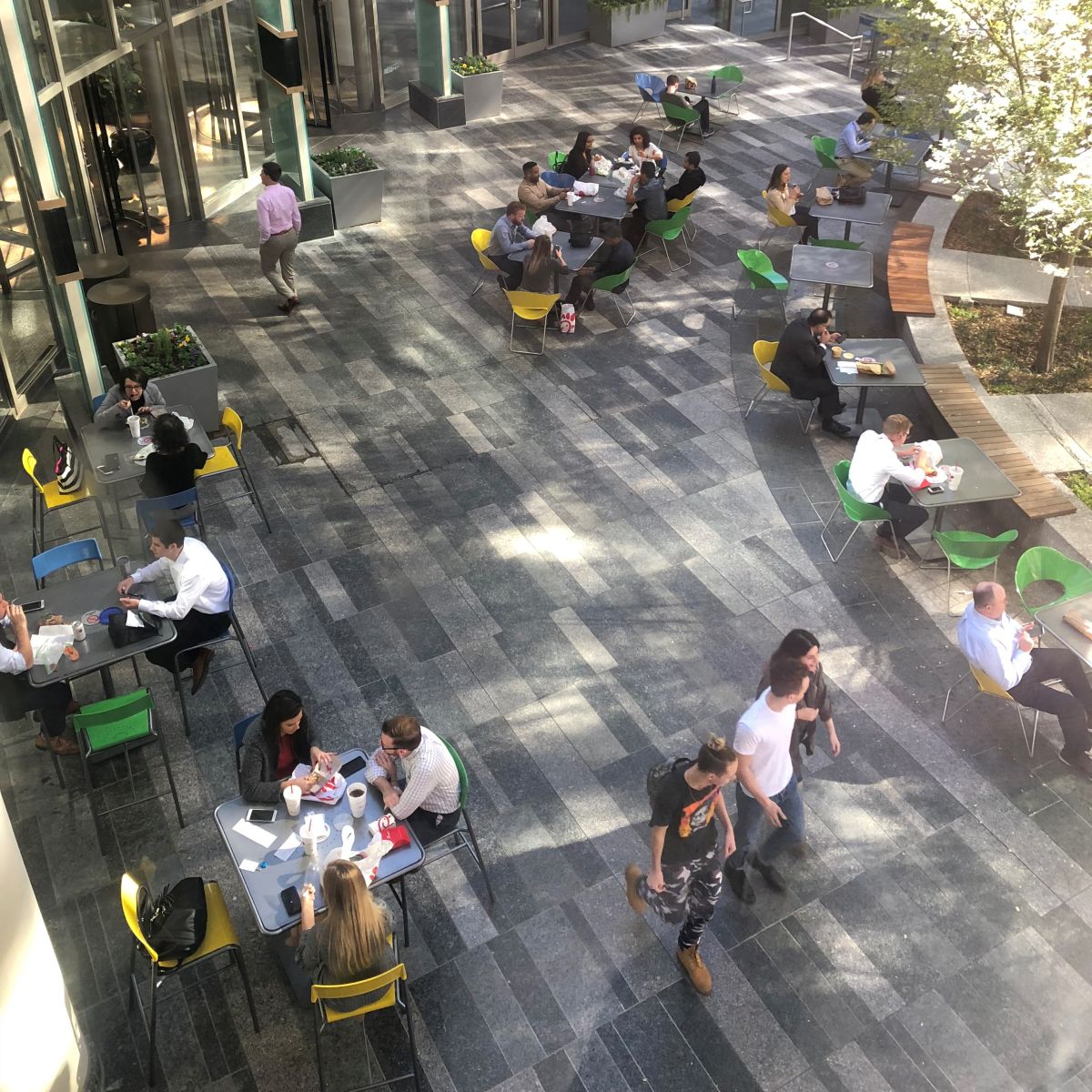 People sitting together at table and chairs in an outdoor corporate plaza