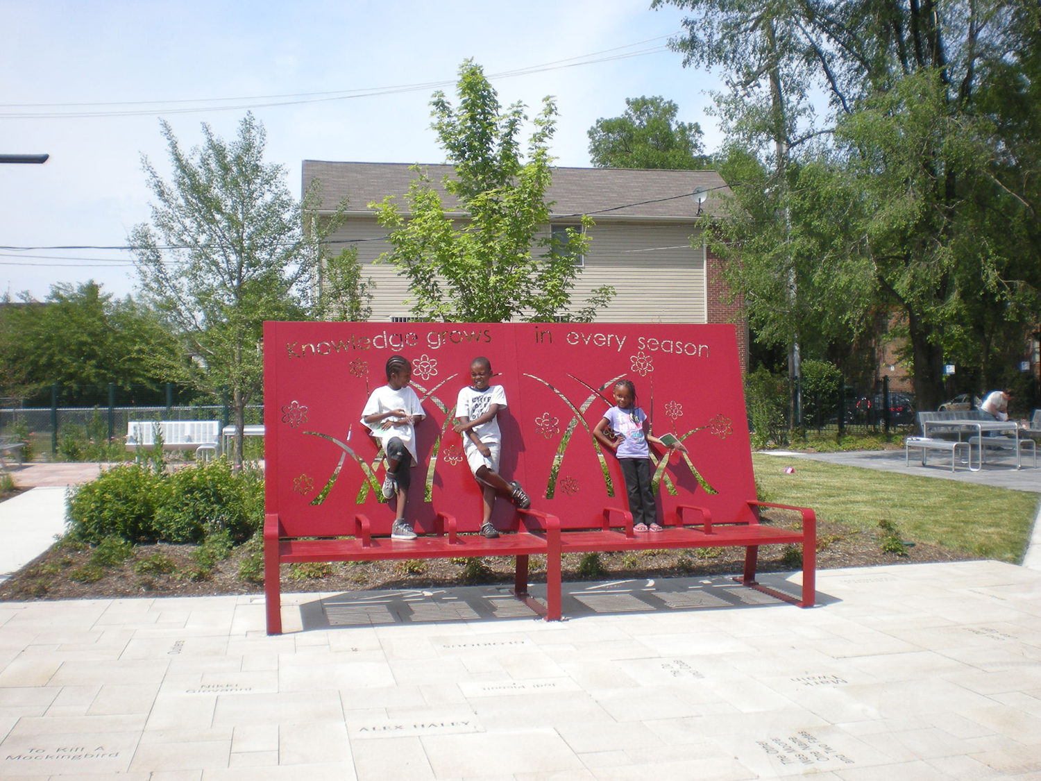 Oversized red bench with children standing on it