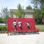 Oversized red bench with children standing on it