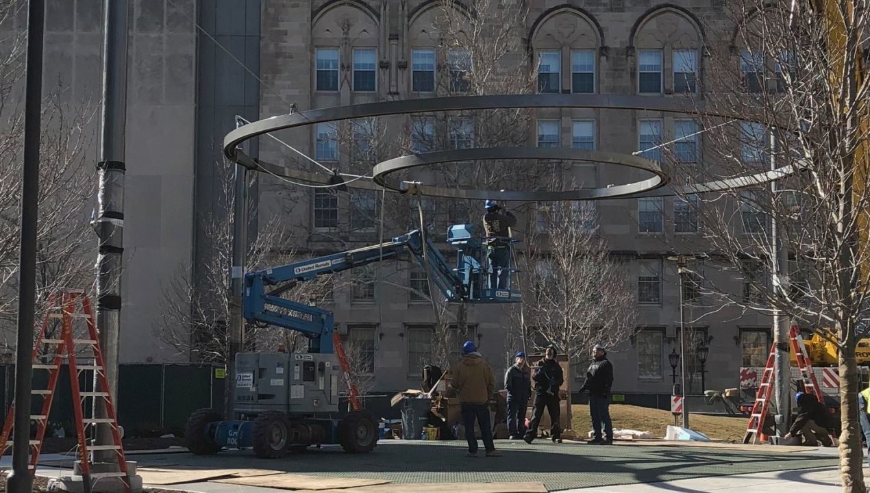 Construction workers suspending two circles in the air