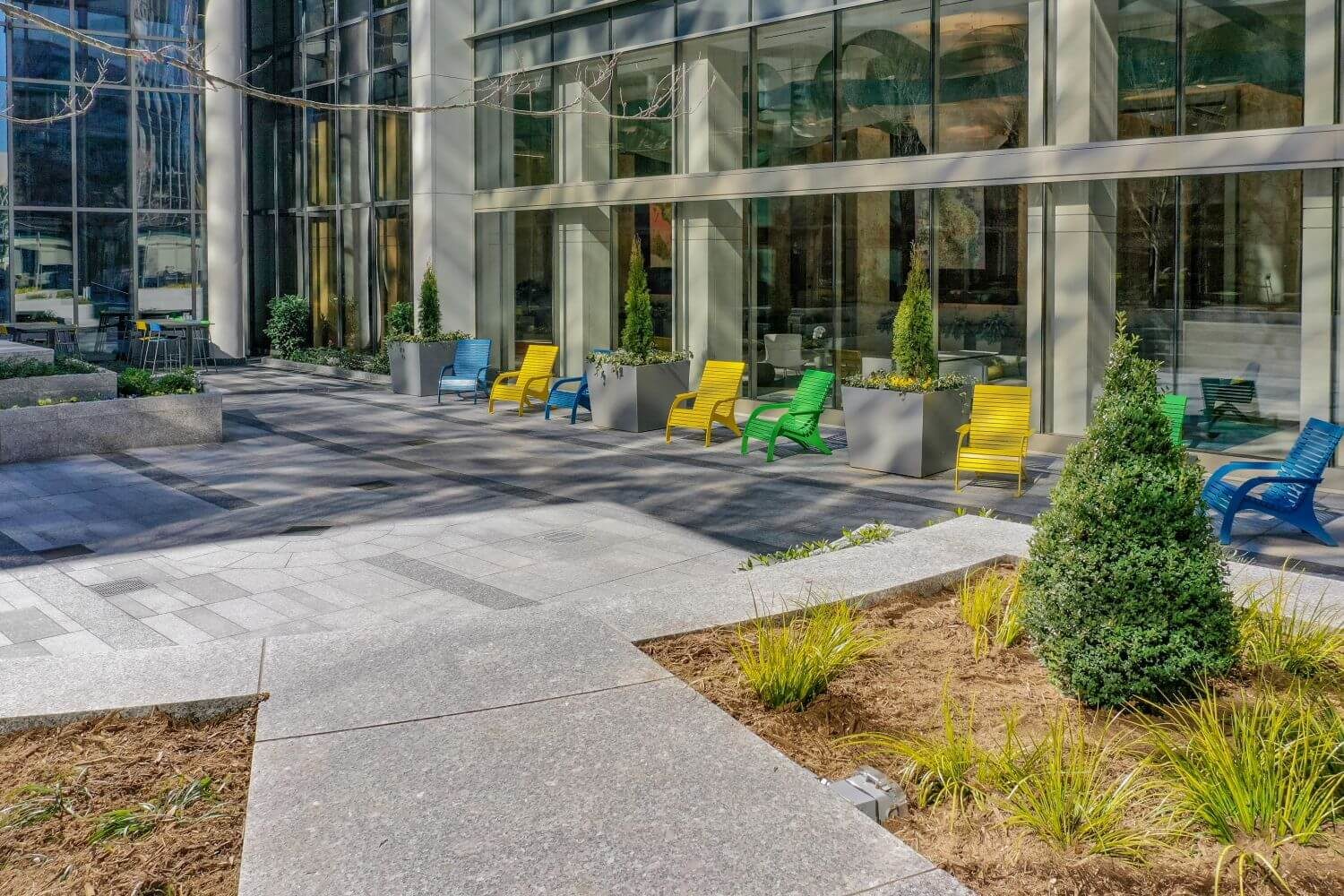 Yellow, Green and Blue patio seating outside glass building