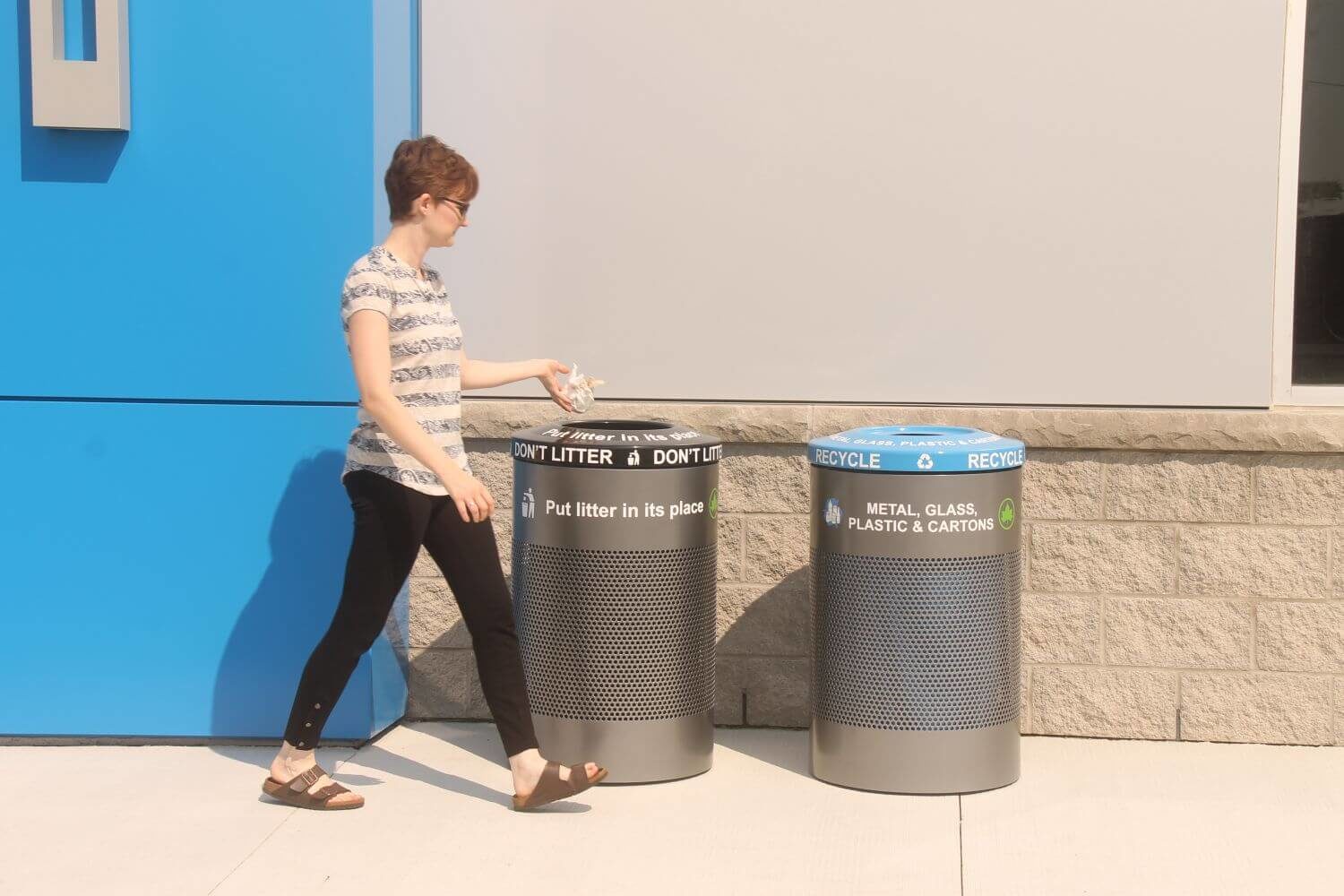 Woman throwing trash into a 600 series trash container