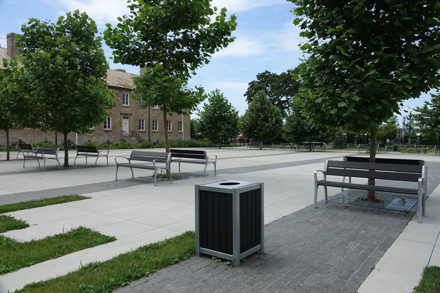Black and Silver bin near benches and trees