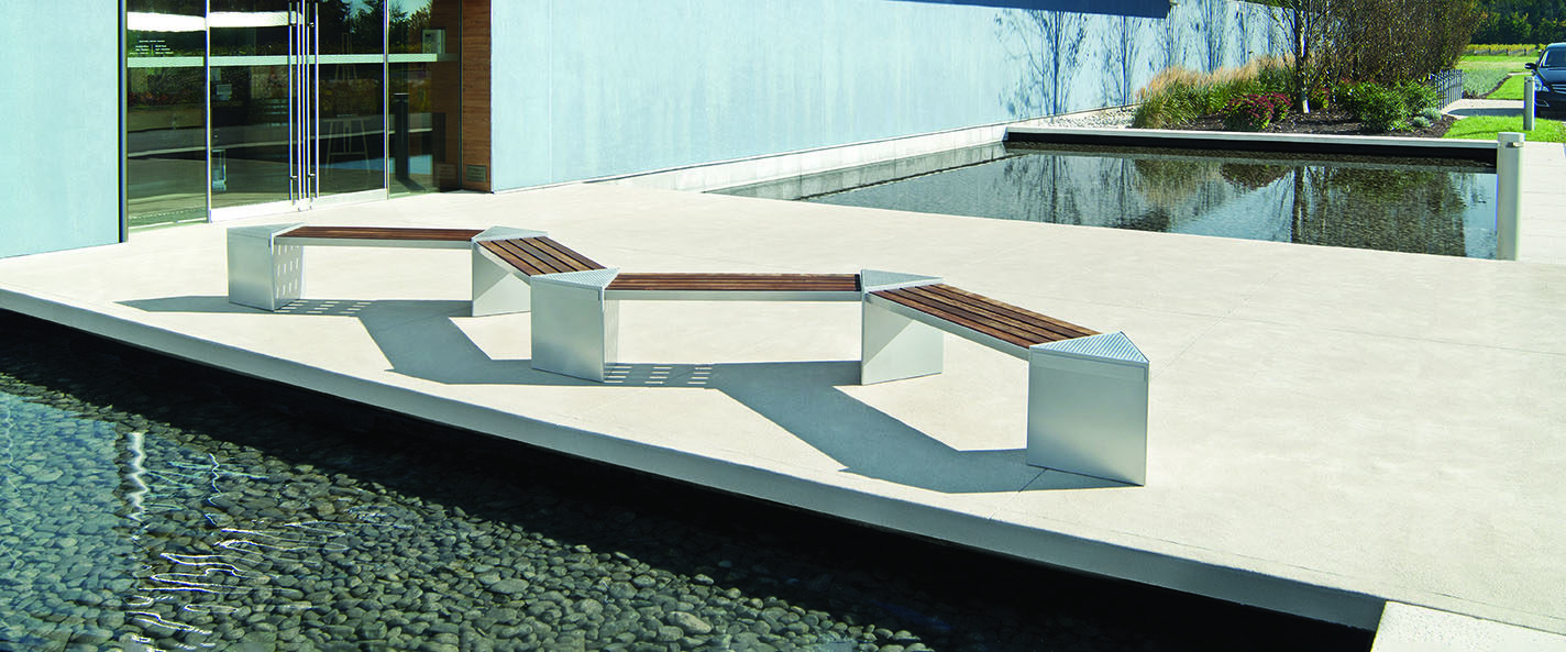 Angled lexicon bench on concrete next to a modern building