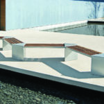 Angled lexicon bench on concrete next to a modern building