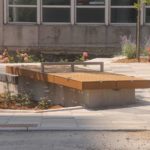 Two identical seating platforms near small flowerbed