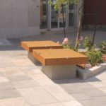 Two identical seating platforms near small flowerbed