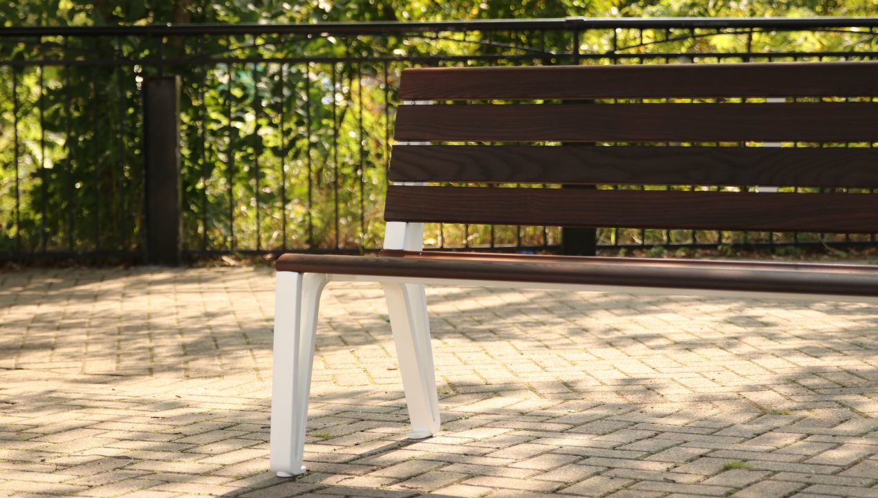 Wood bench close-up with white castings from the Iconic Collection
