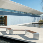 Zig zag Lexicon benches with triangular modules in front of blue building and water
