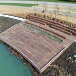 Custom Amphitheater, wooden stage next to water and greenery