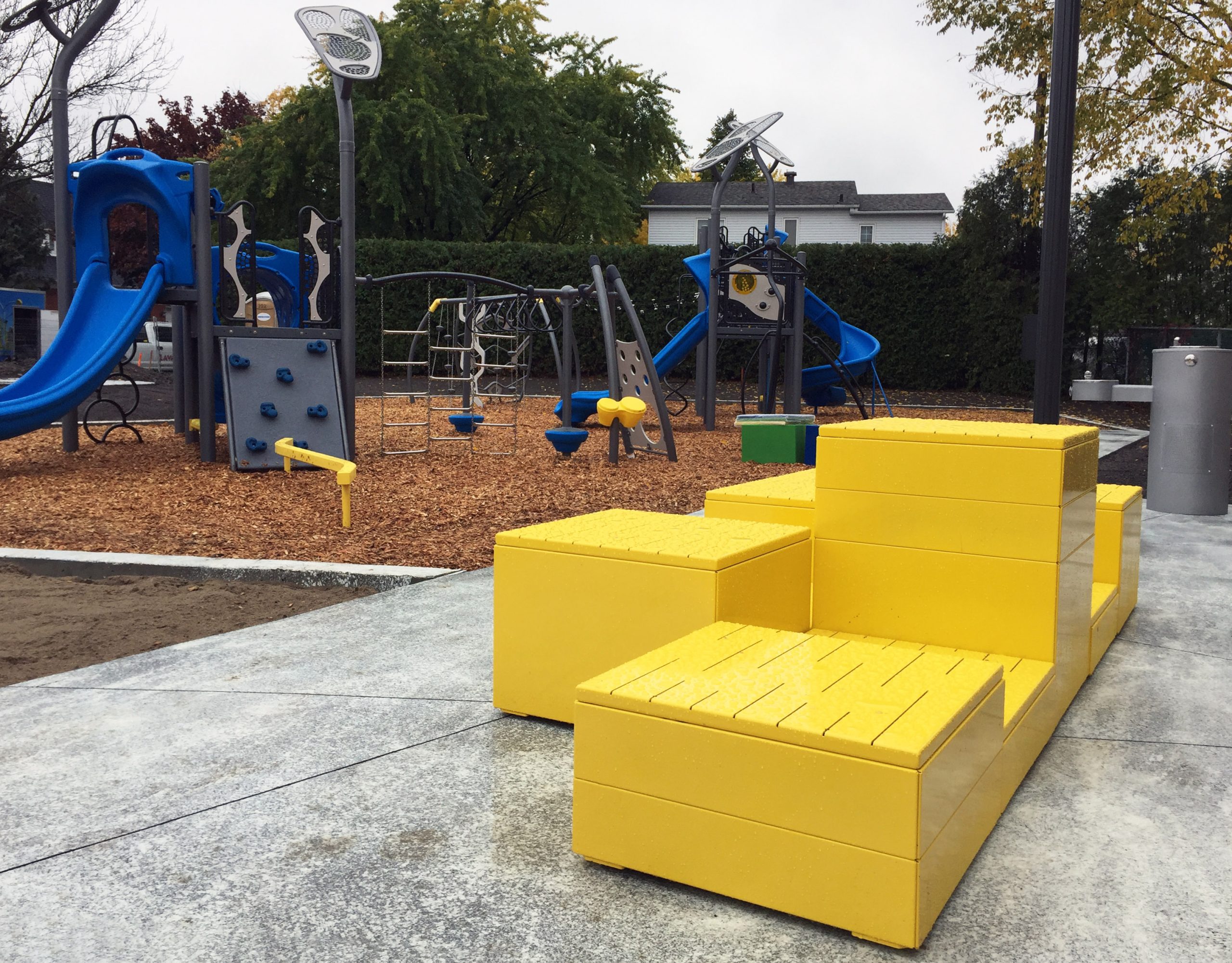 Yellow stacked Pixel layout with steel tops in foreground, playground structure in the background