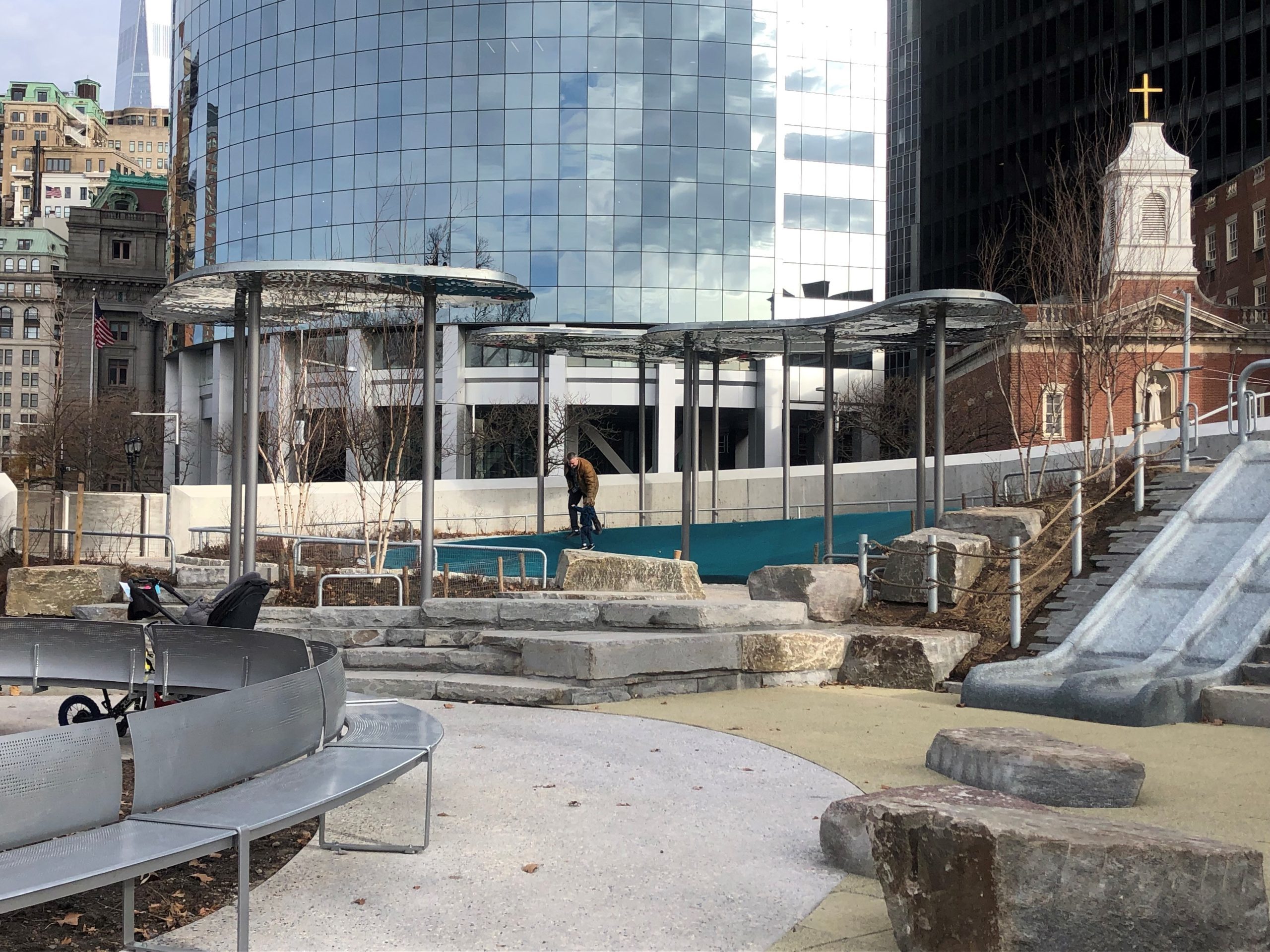 NY_Battery Playscape_Bench_Cloud-Canopies View of Battery Playscape with steel cloud canopies and curved bench. NYC buildings in the background