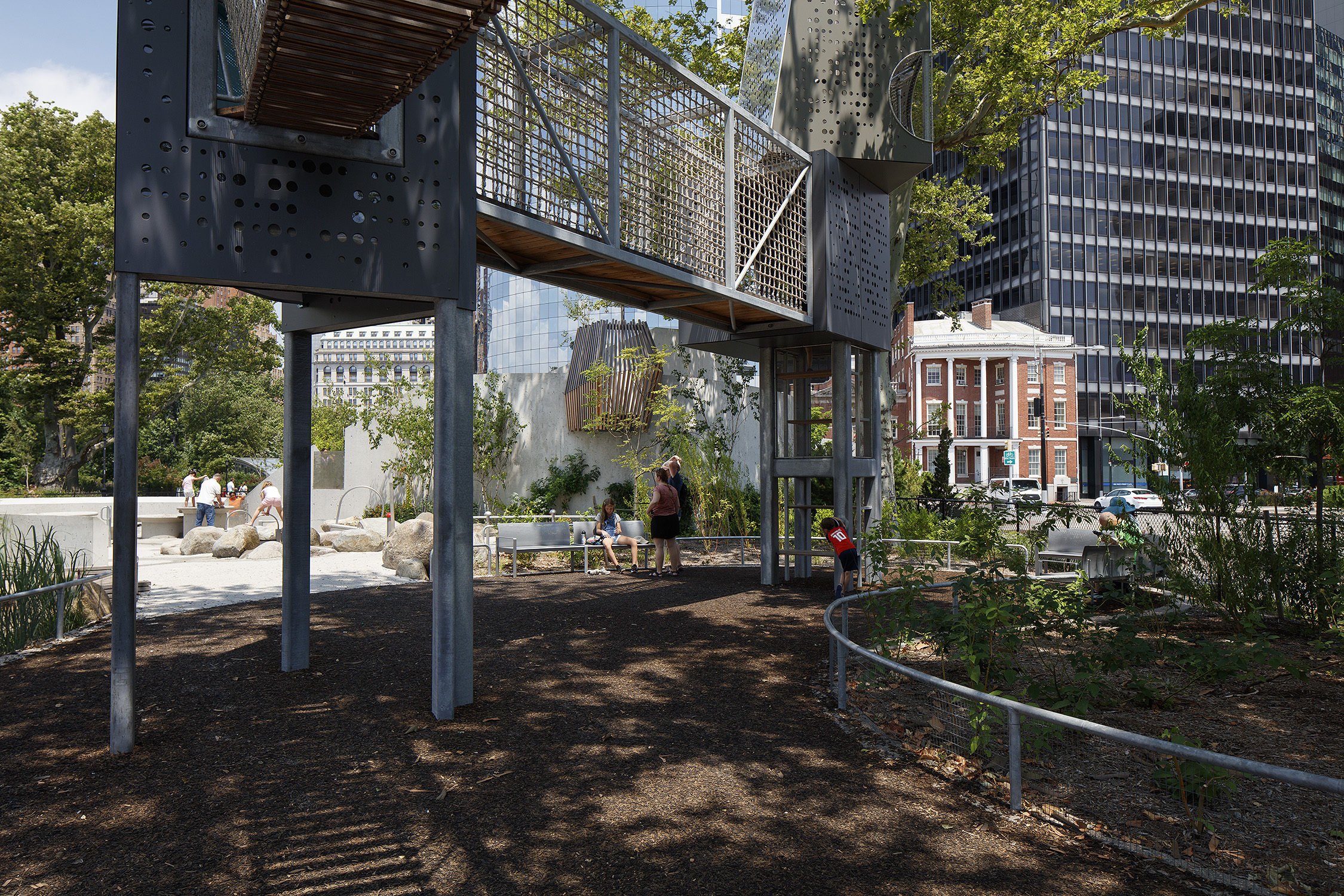 View of the Battery Playcape play structure with Maglin custom curved benches in the background.