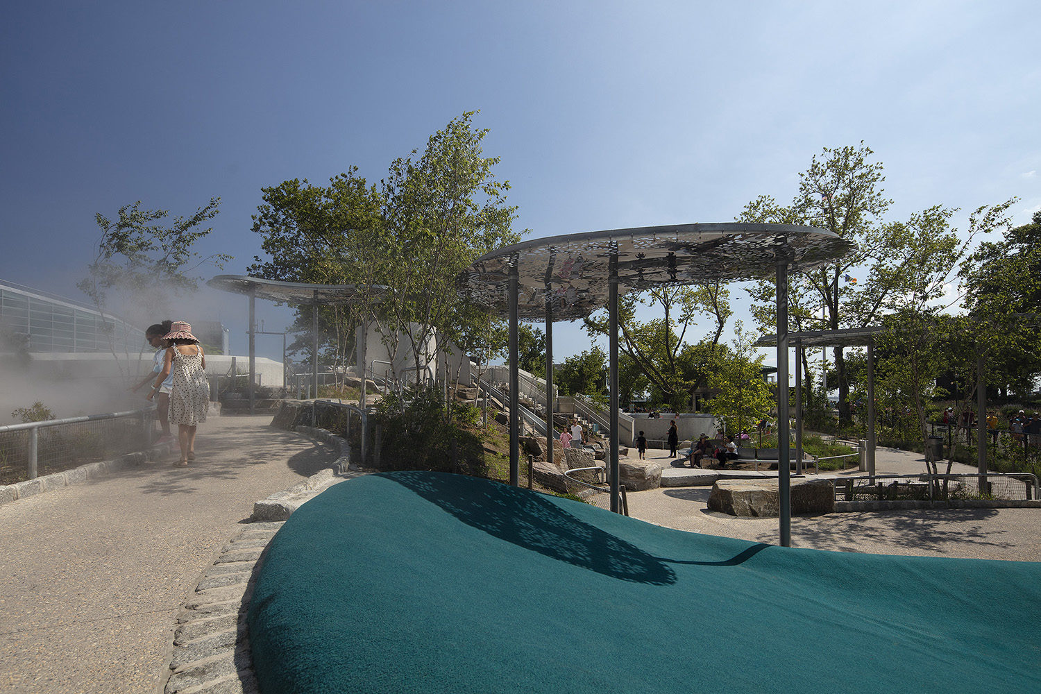 Battery-Playscape_shade-clouds_mist Children play in a mist feature at the Battery Playscape in New York City.