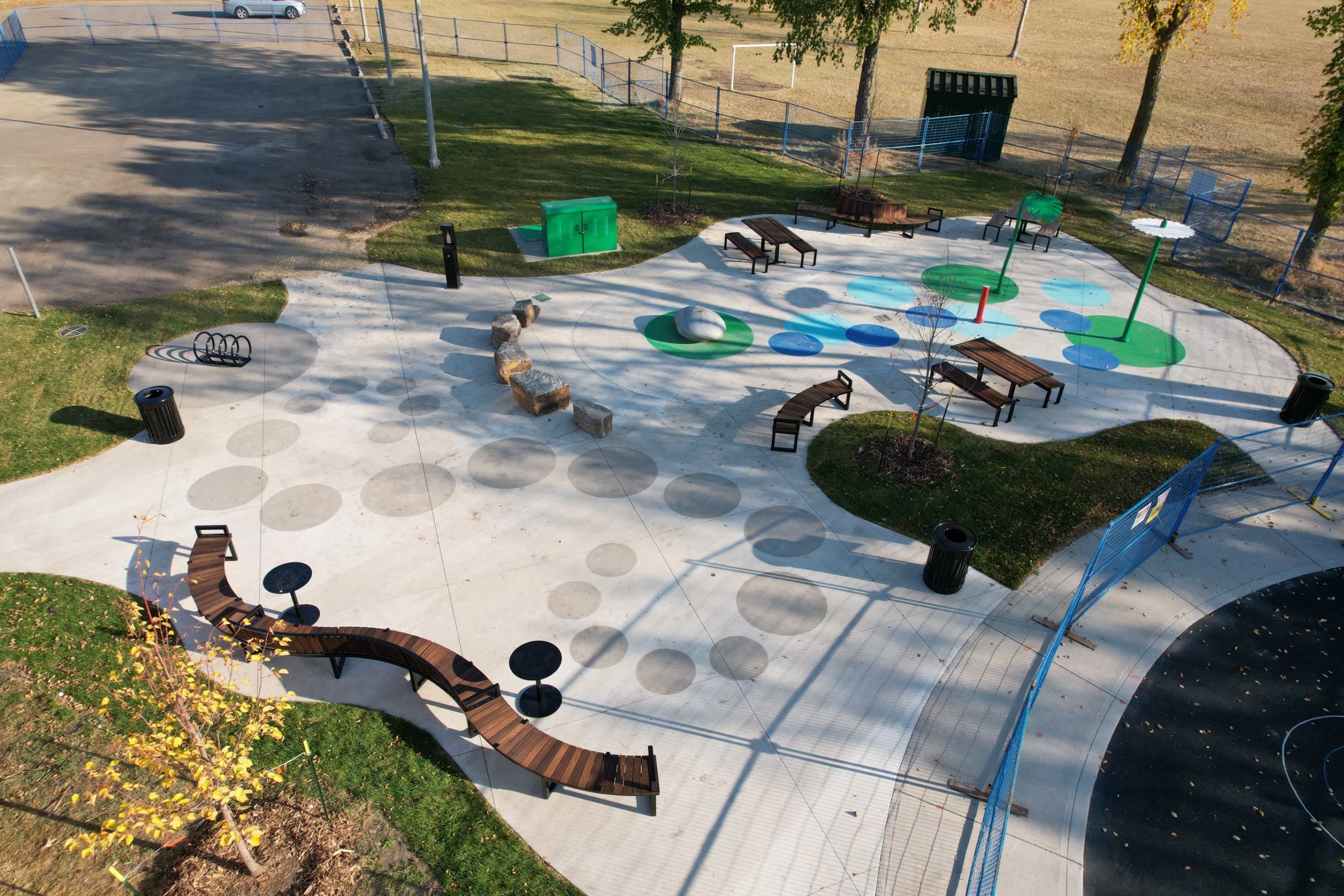 Drone overview of a playground splash pad featuring Maglin Ogden Benches and picnic tables (720 Cluster Seating)