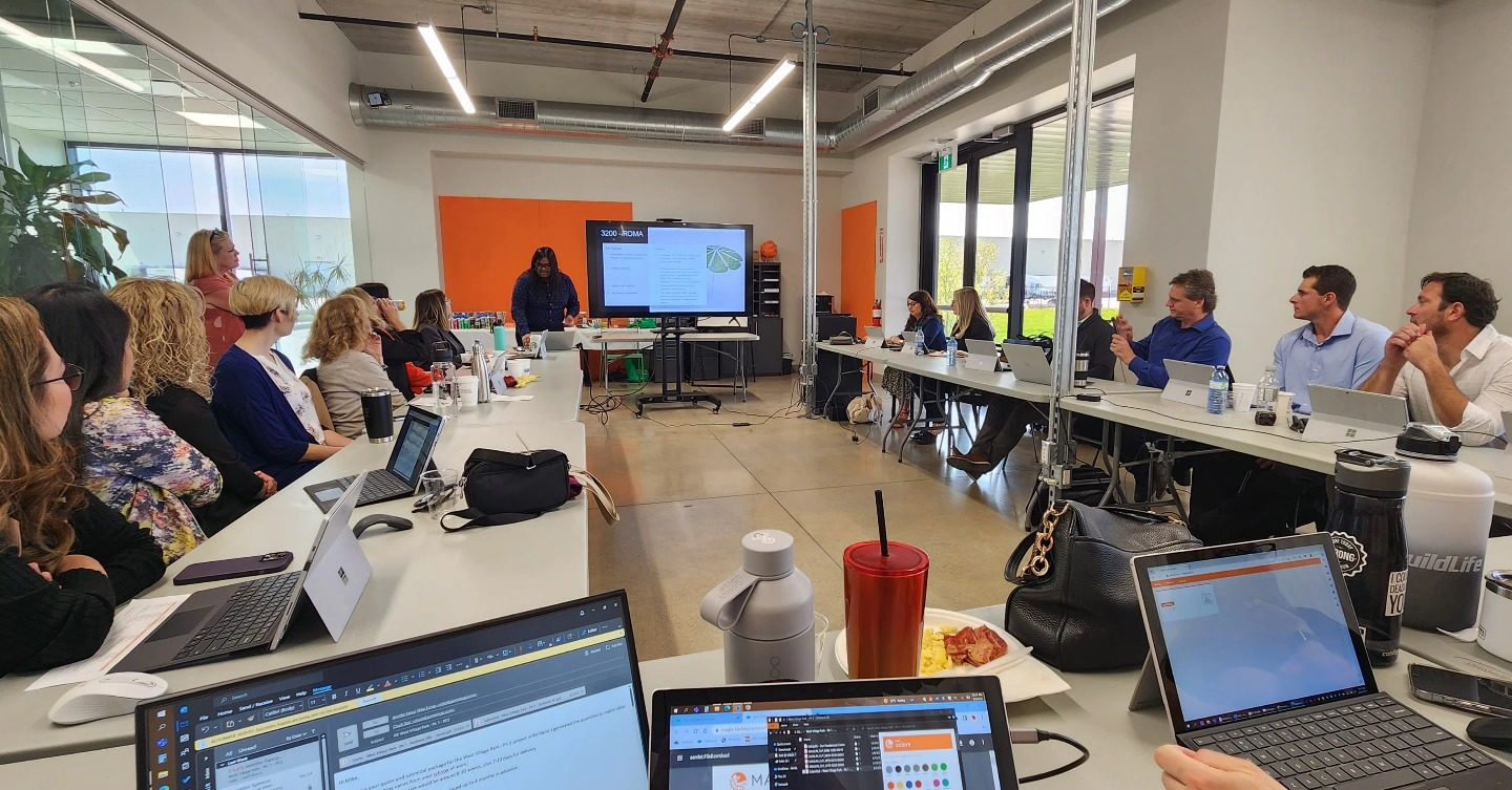 Maglin employees sit and listen to a presentation by product designer Edgar