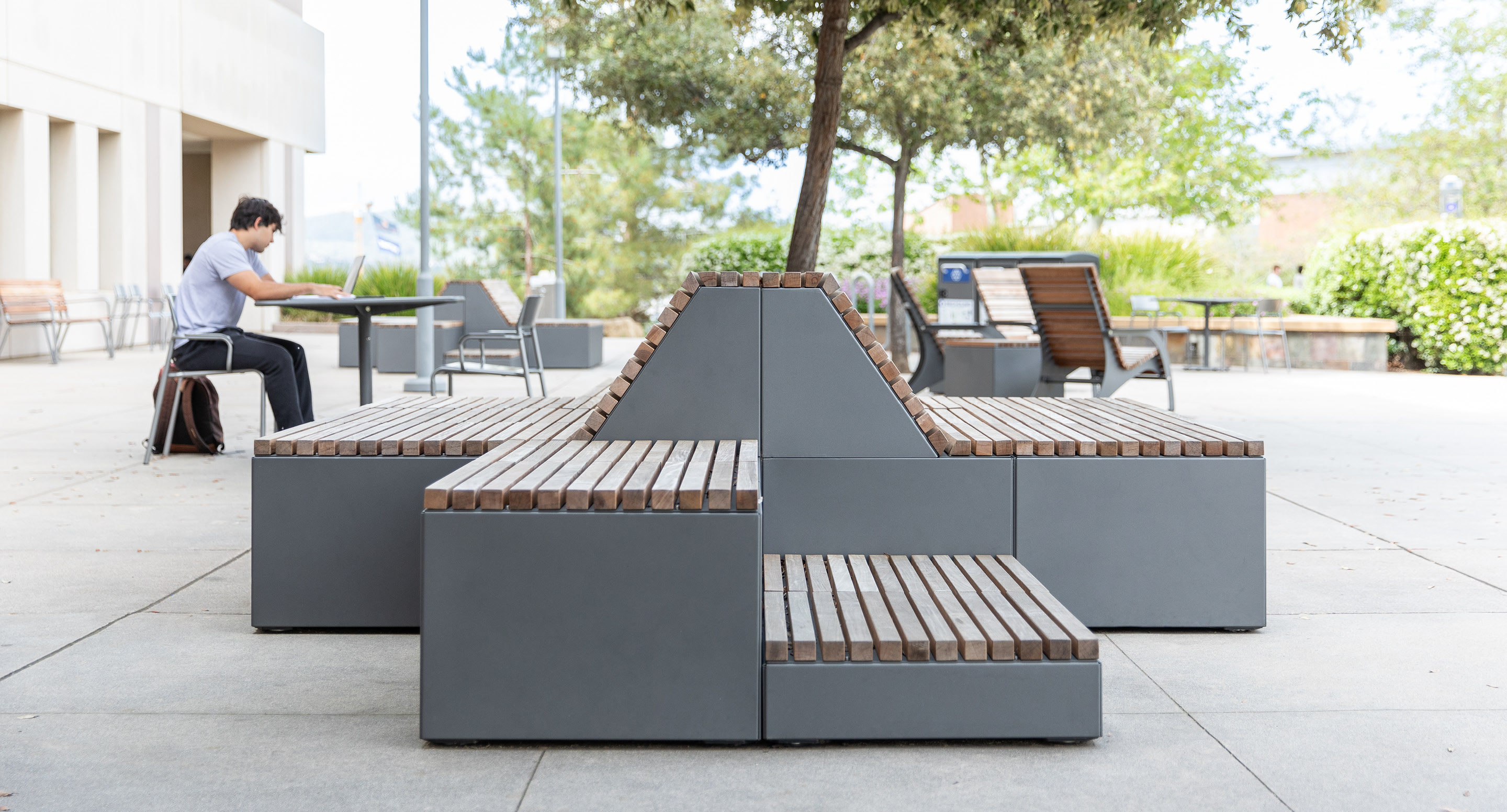 maglin-brochures-hero-img Pixel blocks on school yard patio with student and trees in background