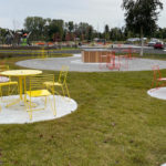Yellow and orange Kontur chairs and cafe tables in a park setting