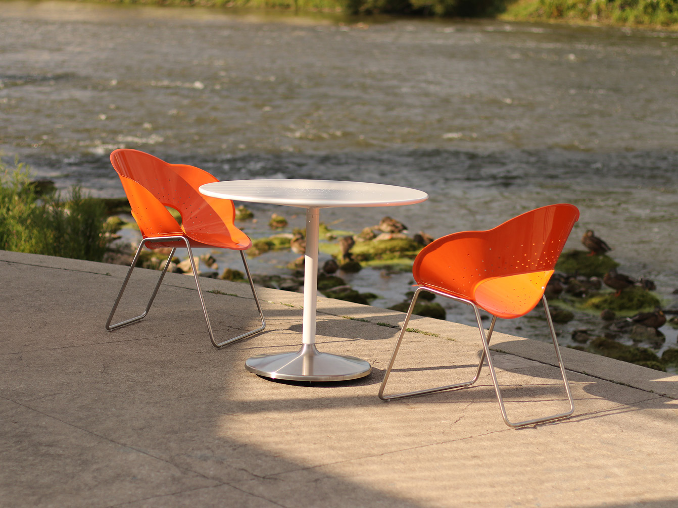 Battery chairs and table against riverbank