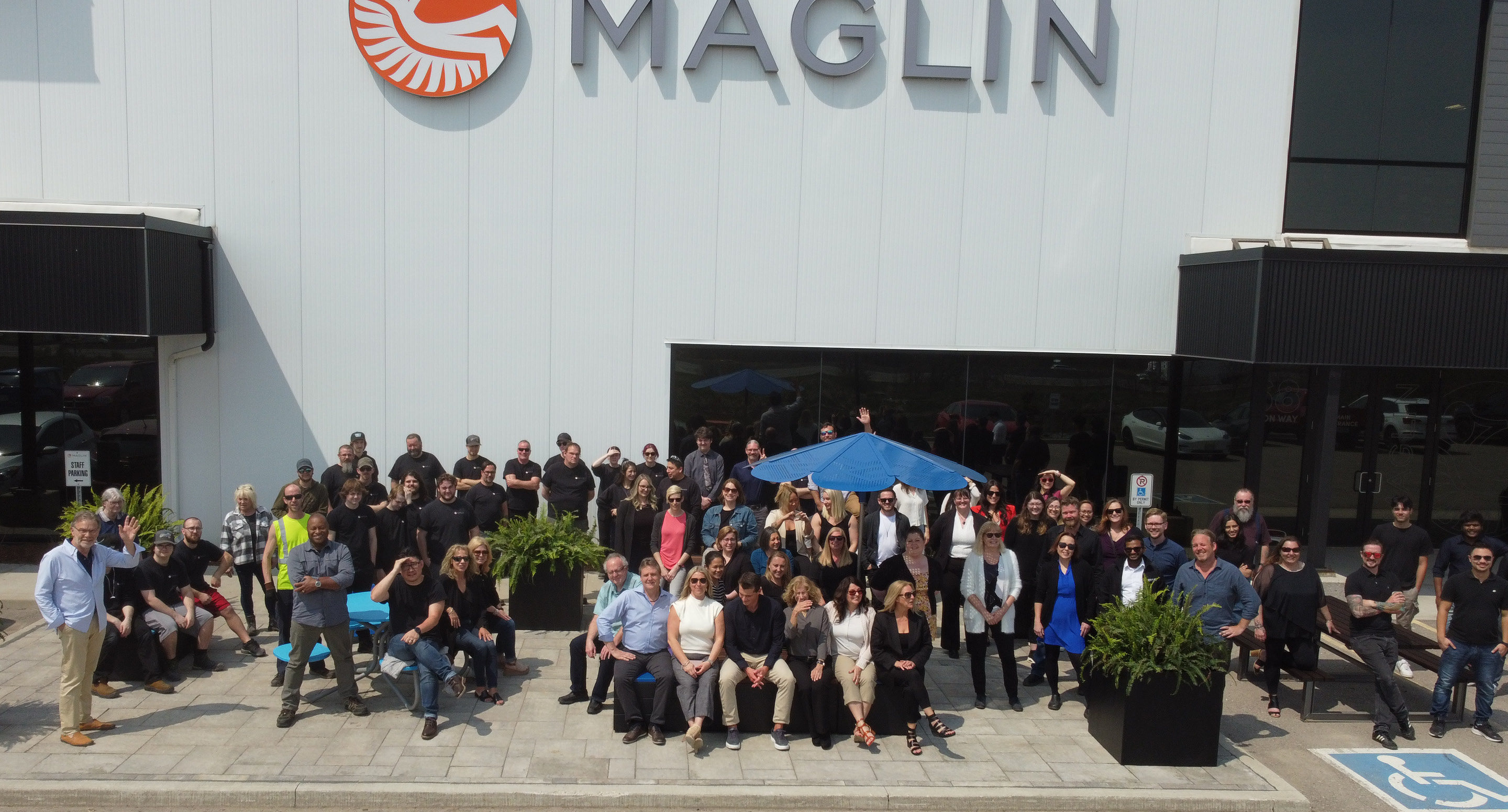 Maglin team posing outside Maglin head office on sunny day